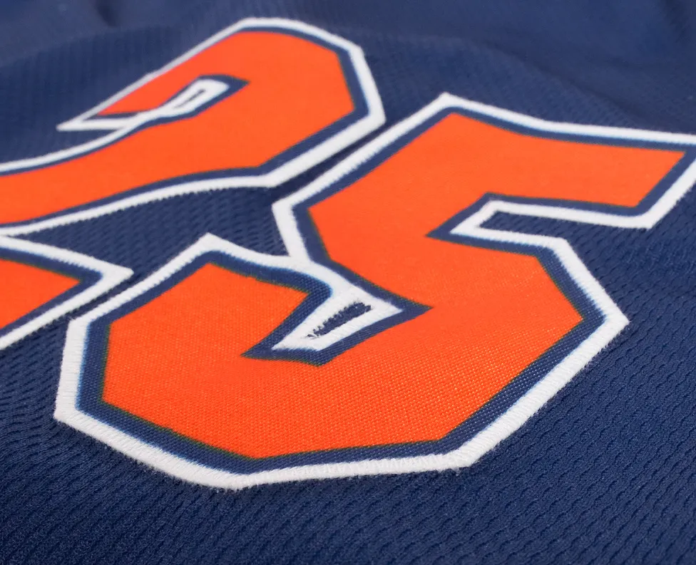 Nahaufnahme einer blauen Sporttrikots mit der Nummer 25 in leuchtendem Orange.