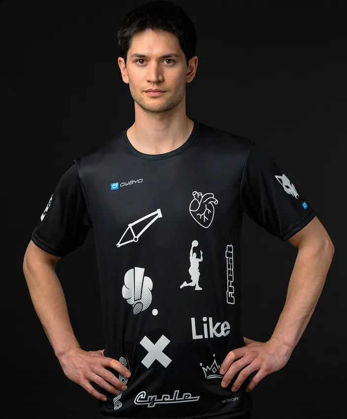 Ein Mann trägt ein schwarzes Sportshirt mit verschiedenen weißen Symbolen und Logos.