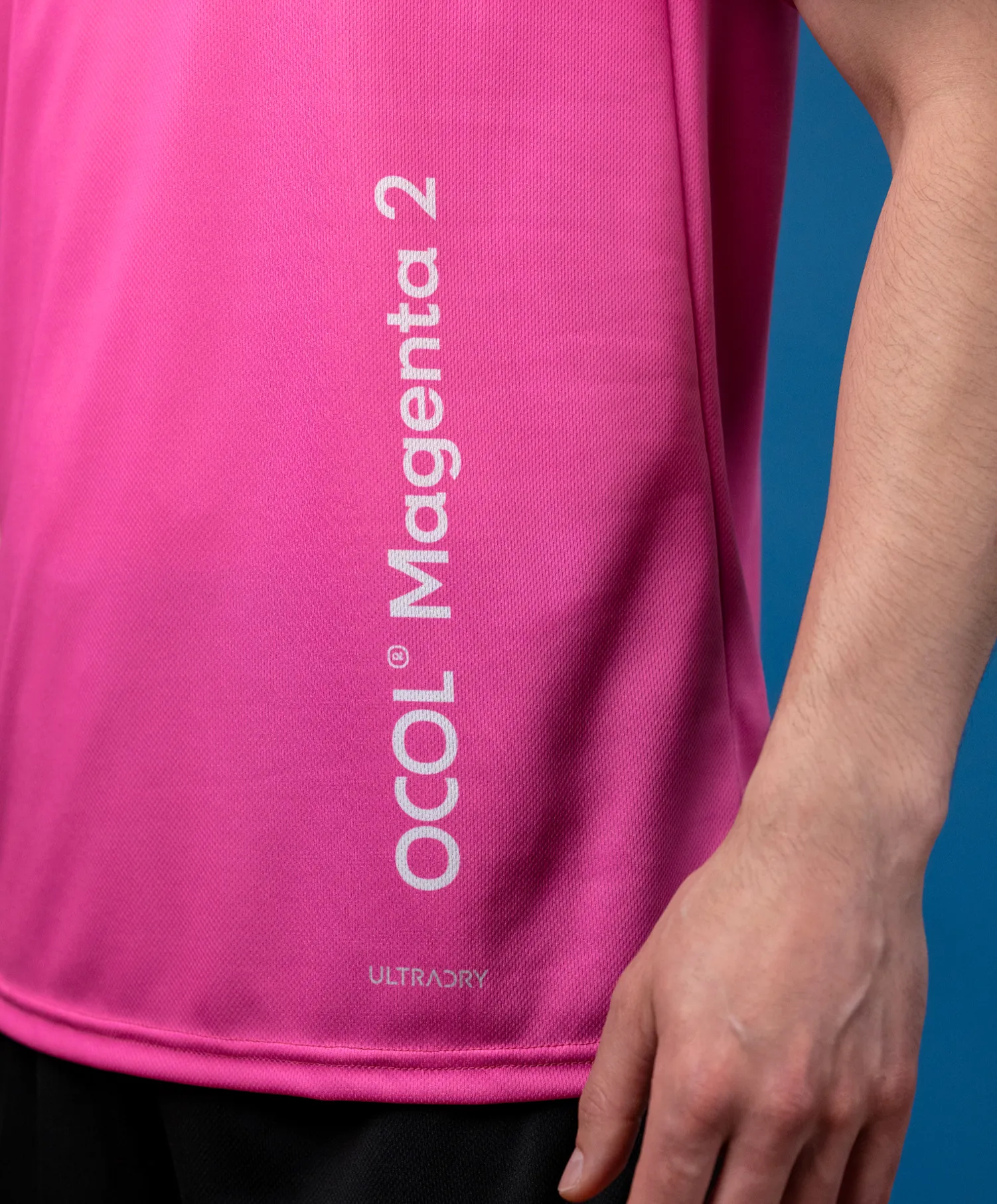 Ein pinkes Sportoberteil mit einem Logo und der Aufschrift 'Magenta 2'.