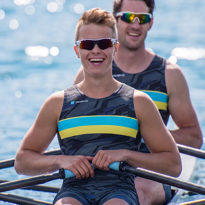 Zwei Ruderer in einem Boot tragen stylische, maßgeschneiderte Sportbekleidung mit einem modernen Muster und lebendigen Farben.