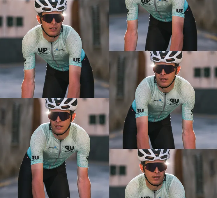 Ein Radfahrer in einem maßgeschneiderten, hellblauen Trikot mit dem Logo 'UP cycling' und 'owayo' auf der Brust, der auf einer Straße fährt.